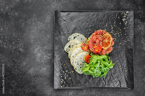 Salmon tartar with avocado on a black background