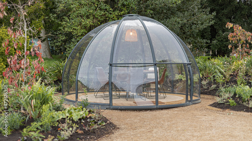  Clear dome in a garden with a dining table inside photo