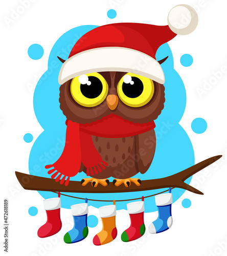 An owl in a scarf and a hat sits on a branch. Christmas character