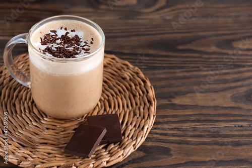 Moccacino coffee on coconut milk with chocolate on a wooden table. Horizontal orientation, copy space. photo