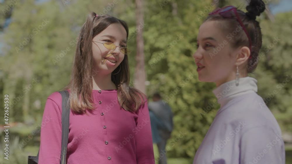 Girl considers new girlfriend earrings in the park. Examining an earring touching it. Girl considers new girlfriend earrings in the park. Examining an earring touching it.