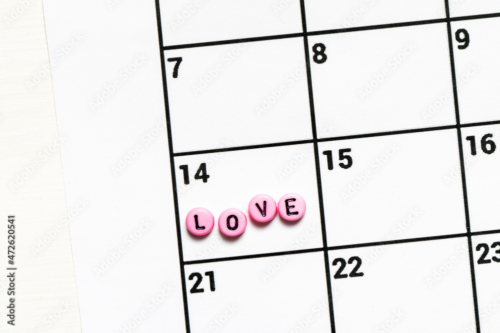 Calendar page with written block LOVE on February 14. Valentines day. Concept of holidays and love. Calendar page with written block LOVE on February 14. Valentines day. Concept of holidays and love.