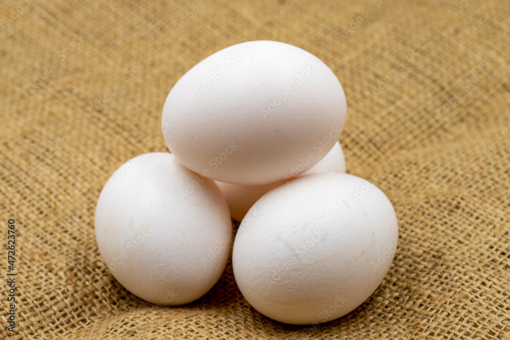Egg carton on jute fabric. close-up white egg. horizontal view Egg carton on jute fabric. close-up white egg. horizontal view