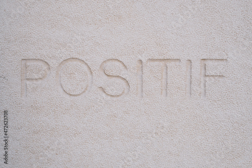 Mot positif gravé dans une pierre blanche