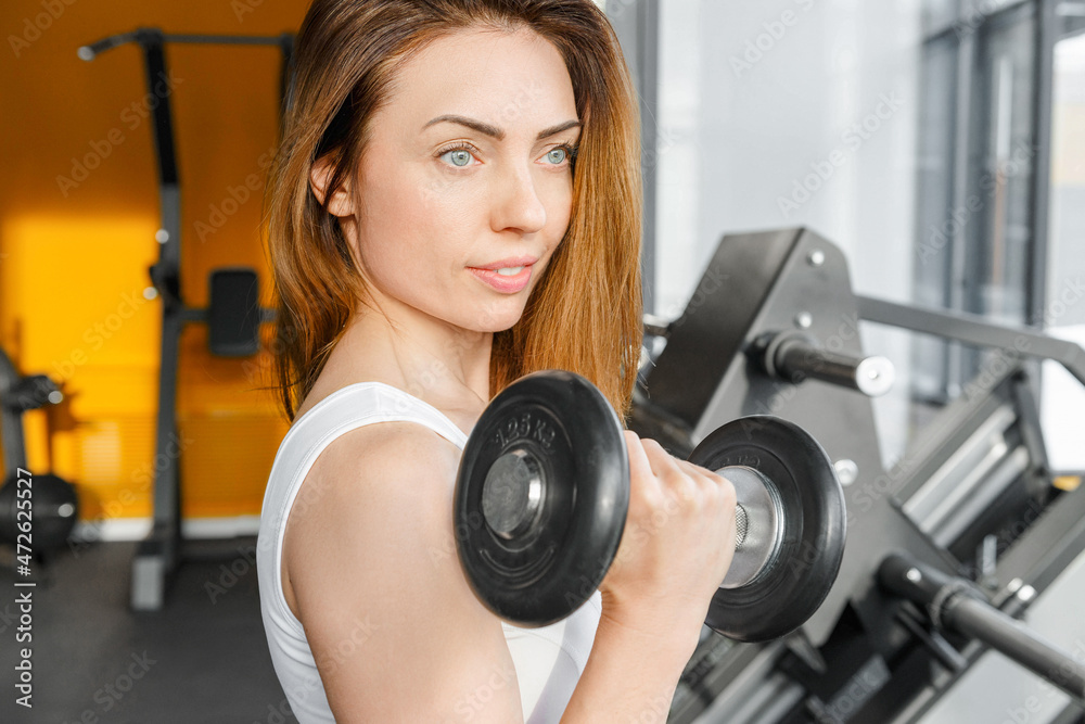 Female hard work at gym with dumbbells push ups. Strong woman at gym Female hard work at gym with dumbbells push ups. Strong woman at gym