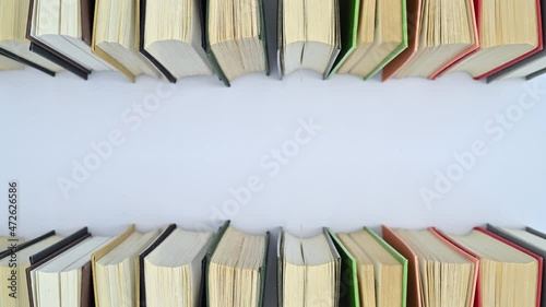 Hardcover retro styled books move on top and bottom of white background. Stop motion