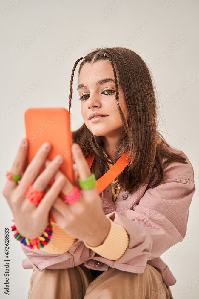 Teenage girl holding smartphone and shooting herself at the camera Teenage girl holding smartphone and shooting herself at the camera