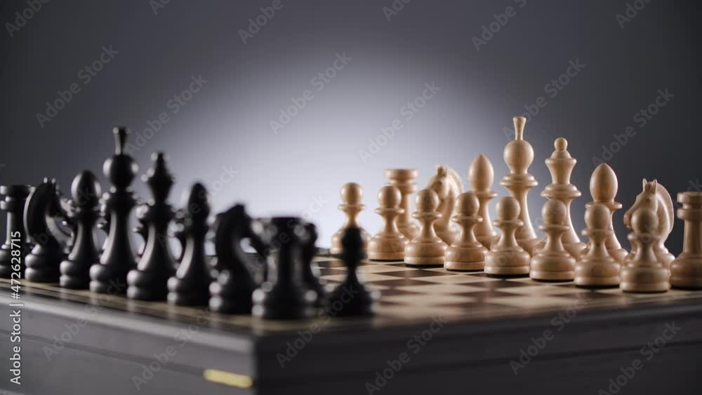 rotating chessboard with lines of white and black wooden chess figures ready to play rotating chessboard with lines of white and black wooden chess figures ready to play