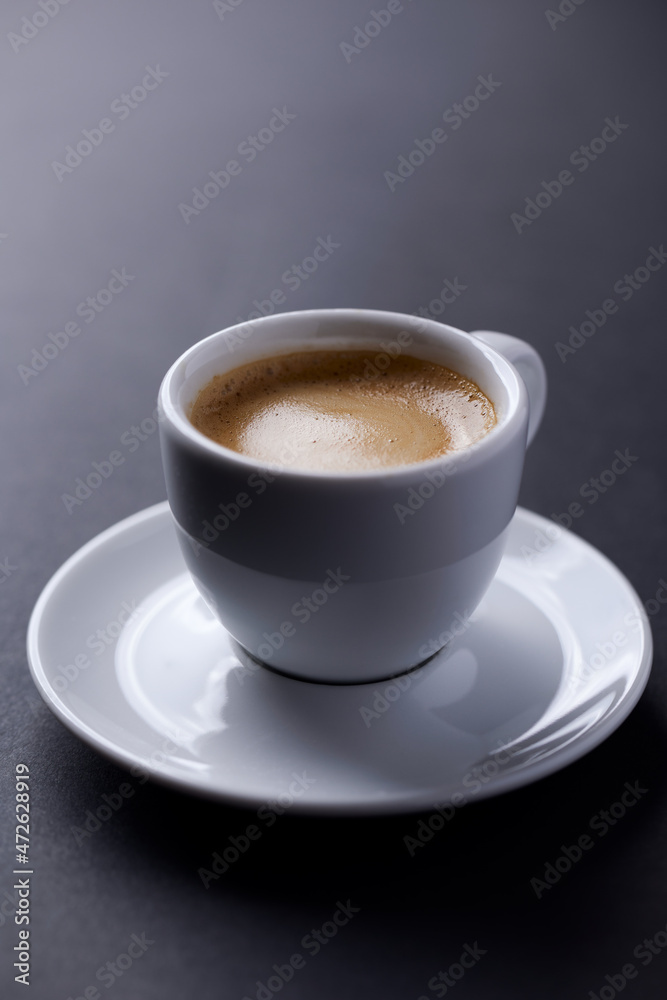 Cup of coffee on dark paper background. Close up.	