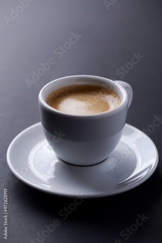 Cup of coffee on dark paper background. Close up. 