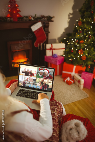 Santa claus making laptop christmas group video call with smiling caucasian family and friends