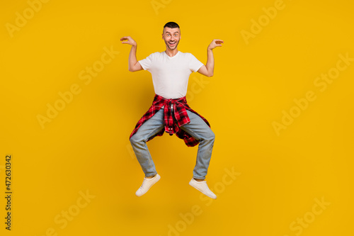 Full length body size photo man jumping fooling childish isolated bright yellow color background