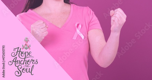Woman with clenched fists and breast cancer awareness slogan on pink background  copy space