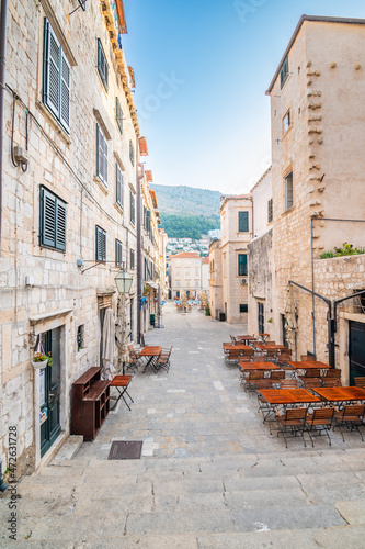 Table near the restaurants at Dubrovnik old town square. Summer morning after sunrise. Ancient town in Croatia.