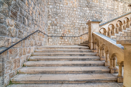 Entrance to the old city of Dubrovnik after Pilar gate. Small ancient street with stairs and old city walls. UNESCO heritage. © Martin