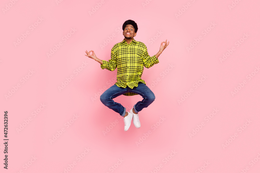 Full size photo of young cool brunette guy jump wear shirt jeans sneakers isolated on pink background