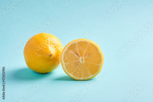 one limon with a cut lemon lie on a blue background