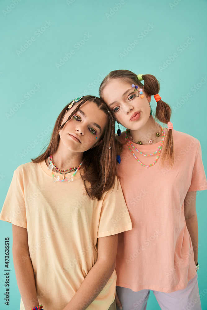 Modern teenagers standing close to each other and looking at the camera Modern teenagers standing close to each other and looking at the camera