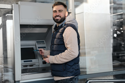 Young man with credit card near cash machine outdoors © New Africa