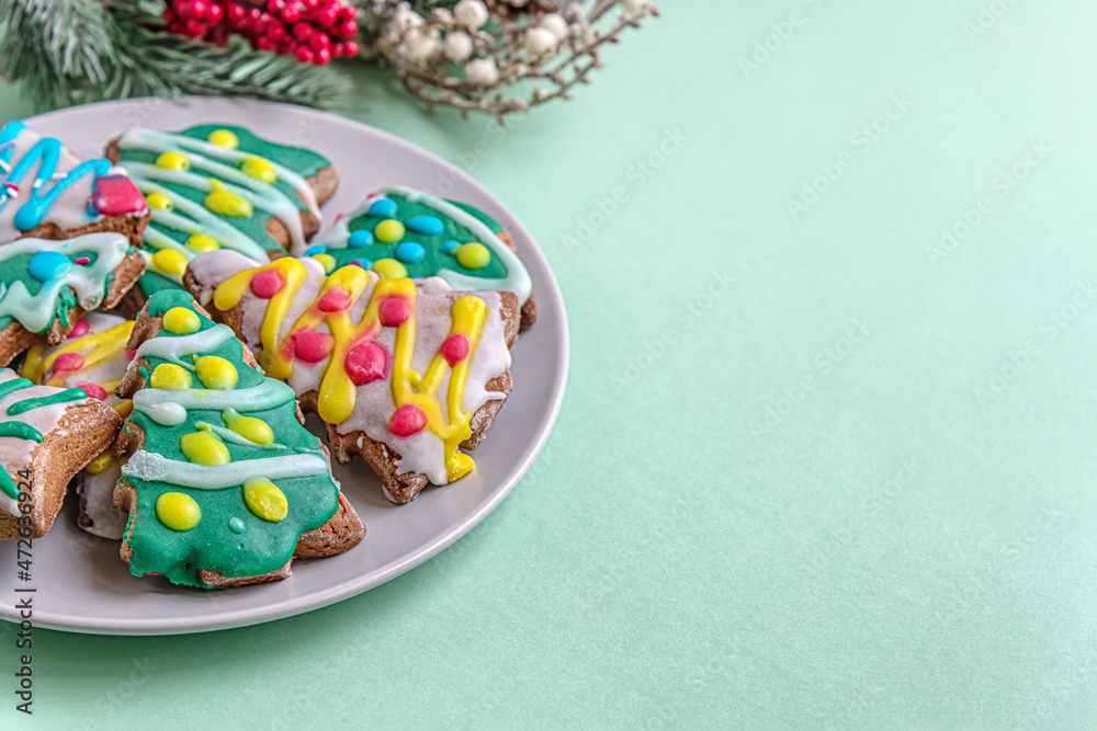 festive Christmass background of handmade Christmas gingerbread cookies in the shape of trees decorated with colorful glaze