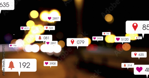 Image of social media icons and numbers over out of focus city and car lights