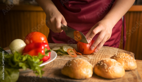 Close-up of a woman cutting vegetables with a sharp kitchen knife. Cooking healthy organic food in the home kitchen. The concept of a natural clean diet and a healthy lifestyle. selective focus