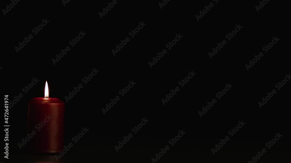 One red burning candle on a black background. Copy space. Video screensaver, intro, footage for titles and captions. Holiday halloween, new year, christmas, romance and memory. UHD 4K. One red burning candle on a black background. Copy space. Video screensaver, intro, footage for titles and captions. Holiday halloween, new year, christmas, romance and memory. UHD 4K.