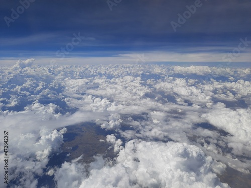 above the clouds, aerial photography of white clouds in the blue sky, Sunrise above clouds from airplane window.