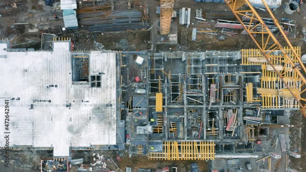 Aerial top down view of a construction site of with an apartment building under construction with tower crane Aerial top down view of a construction site of with an apartment building under construction with tower crane