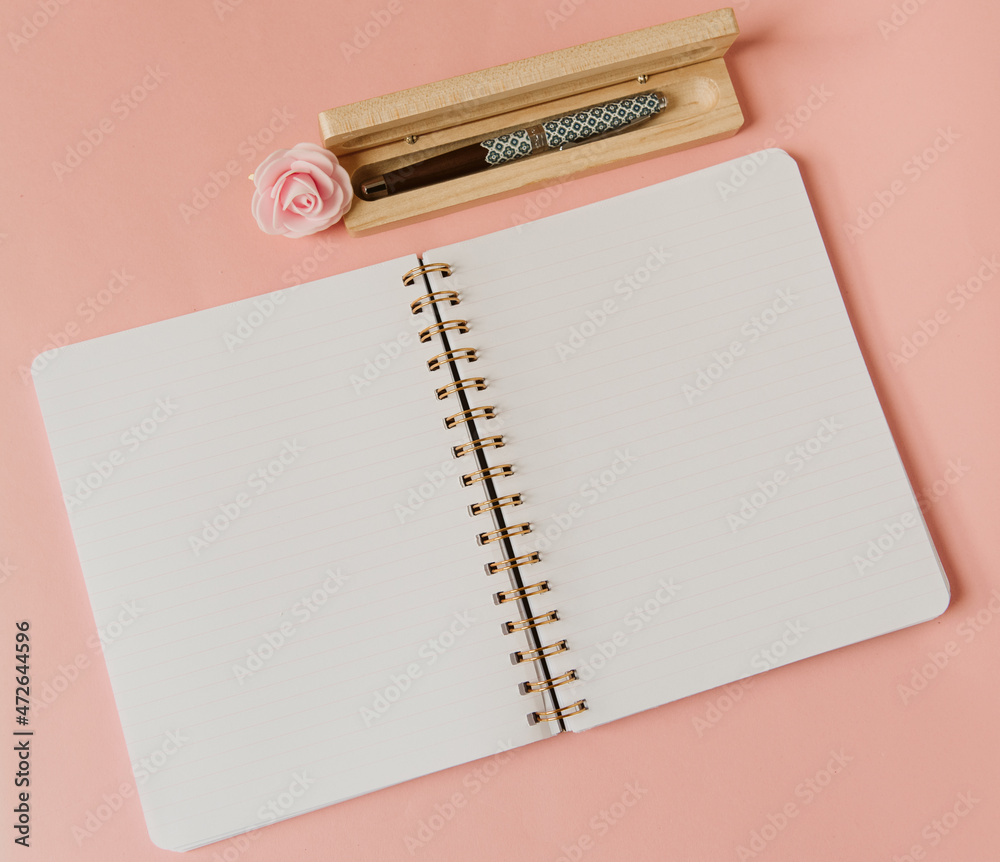 Cahier à spirale ouvert sur des pages blanches avec un stylo plume et