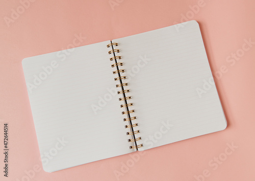 Fotografie Cahier à spirale ouvert sur fond rose - pages blanches