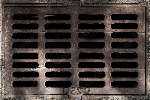 Metal old rusty sewer grate, sanitary hatch built into the asphalt