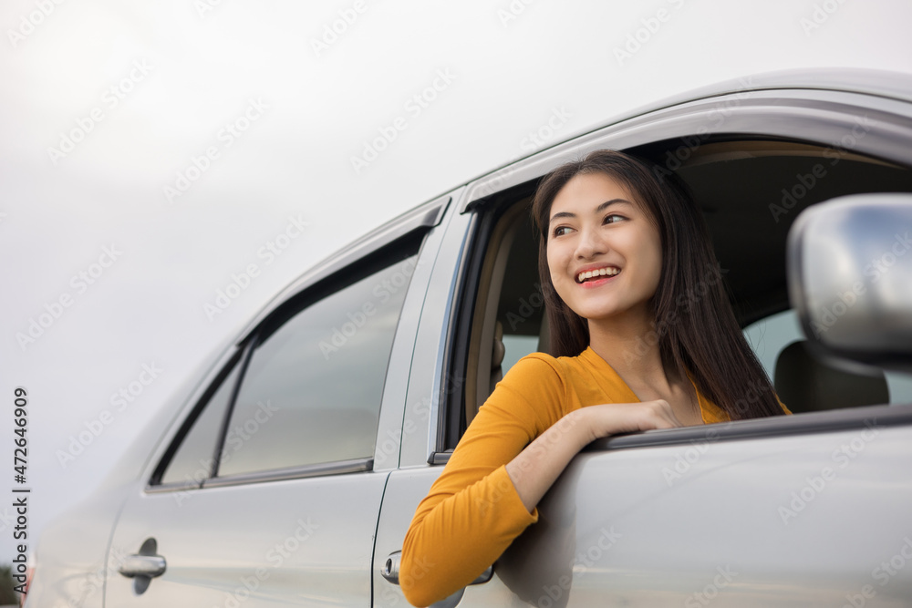 Young beautiful asian women getting new car. she very happy and excited looking outside window. Smiling female driving vehicle on the road on a bright day Young beautiful asian women getting new car. she very happy and excited looking outside window. Smiling female driving vehicle on the road on a bright day