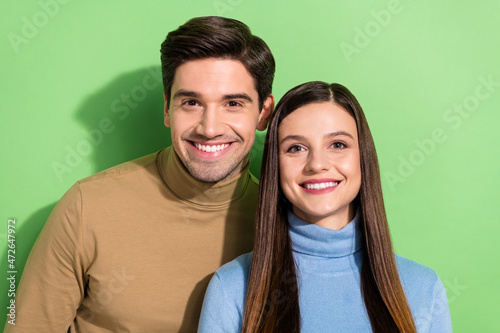 Portrait of two glad satisfied people toothy beaming smile look camera isolated on green color background