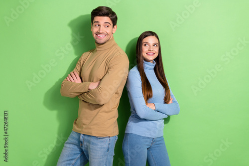 Photo of two cheerful people folded hands look interested each other isolated on green color background