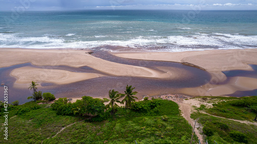 Aerial view of Imbassai beach, Bahia, Brazil. Beautiful beach in the northeast with a river and palm trees. photo