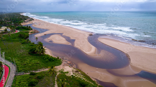 Aerial view of Imbassai beach, Bahia, Brazil. Beautiful beach in the northeast with a river and palm trees. photo