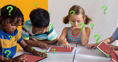 Digital composite of multiracial students using tablet pcs at desk in classroom with question marks