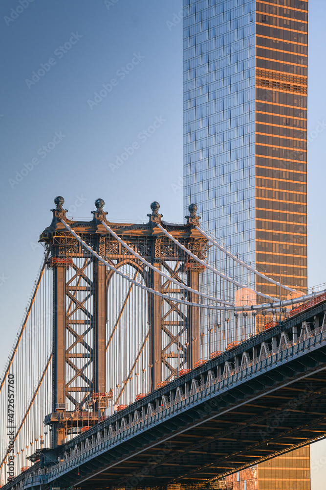 Fototapeta premium Travel to New York. The skyline of Manhattan photographed during a summer sunrise, view to Manhattan Bridge. Landmarks of United States of America. Skyscraper office buildings.