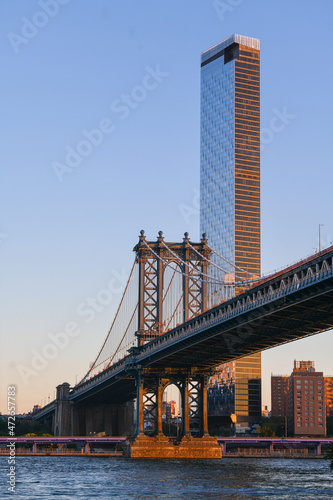 Travel to New York. The skyline of Manhattan photographed during a summer sunrise, view to Manhattan Bridge. Landmarks of United States of America. Skyscraper office buildings. © Dragoș Asaftei