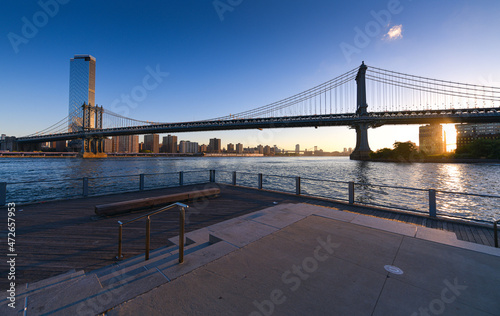 Travel to New York. The skyline of Manhattan photographed during a summer sunrise, view to Manhattan Bridge. Landmarks of United States of America. Skyscraper office buildings.