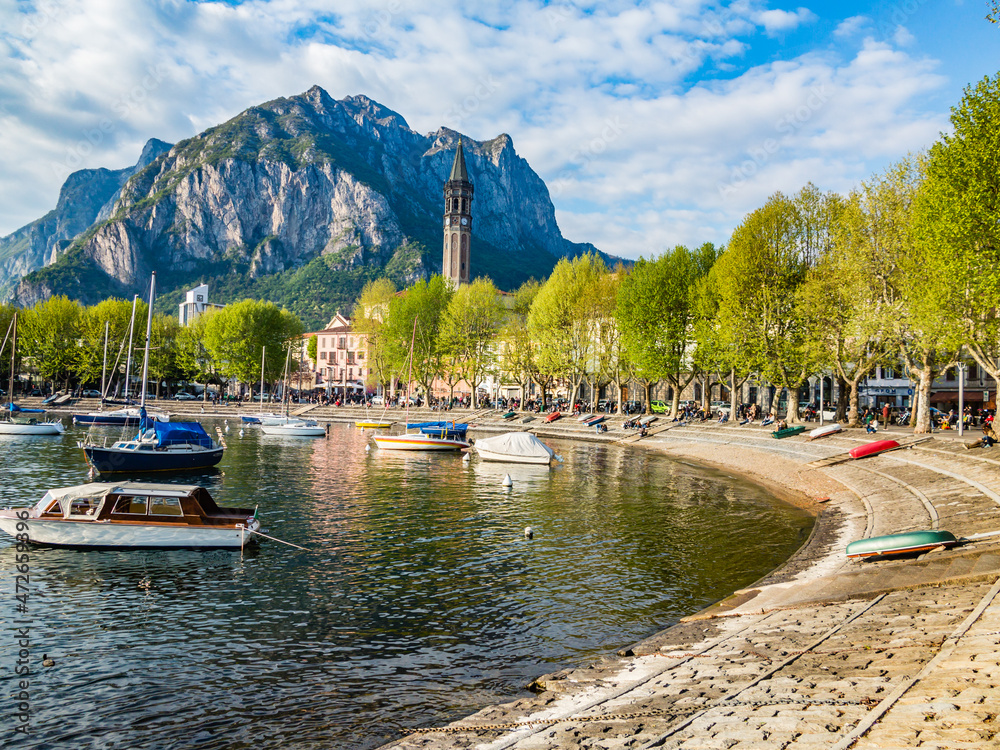 Bay of the city of Lecco in spring where we can see some boats.The road along the Lake with the walk and the tree-lined Avenue.