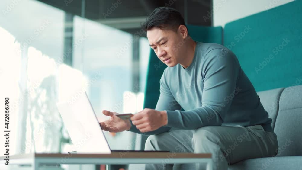 Unhappy Confused, angry asian man shopping online. customer cannot pay by bank credit card. having problems paying feel frustrated stressed with failed transaction internet on computer laptop screen