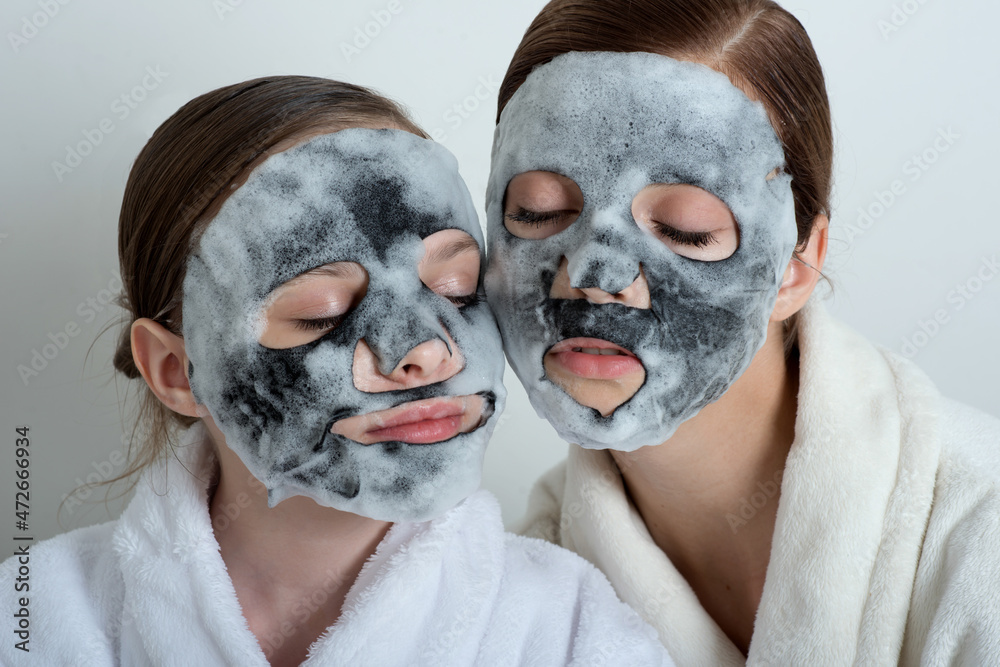 Two girls with a mask their faces. Little girl and young woman enjoy spa treatments. SPA and wellness | Adobe Stock