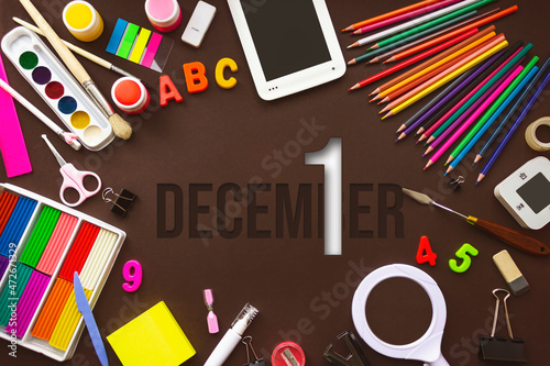 December 1st . Day 1 of month, Calendar date. School notebook and various stationery with calendar day. School and office supplies frame. Winter month, day of the year concept.