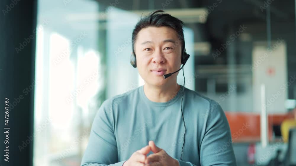 Portrait asian man talking video call with headset looking at camera. Webcam view. Male Freelance Teacher Lecturer Talk Online Support Meeting or Conference. Remote work business conversation Explain