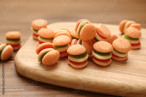 Delicious gummy burger shaped candies on wooden table, closeup