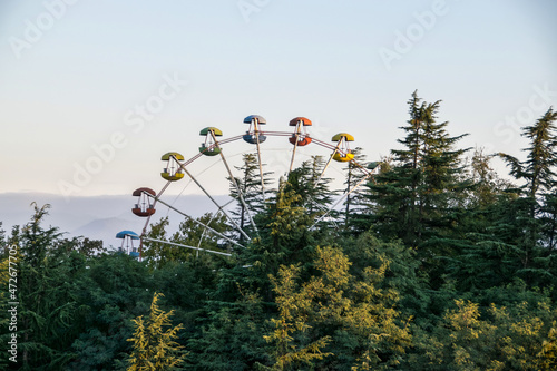 Das Riesenrad des Freizeitpark in Kutaissi (Georgien) ragt einsam aus den Baumwipfeln photo