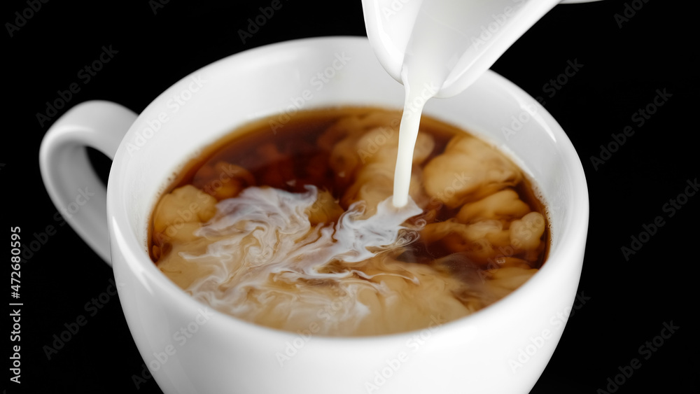 Coffee creamer. Pour cream in black coffee close up Coffee creamer. Pour cream in black coffee close up
