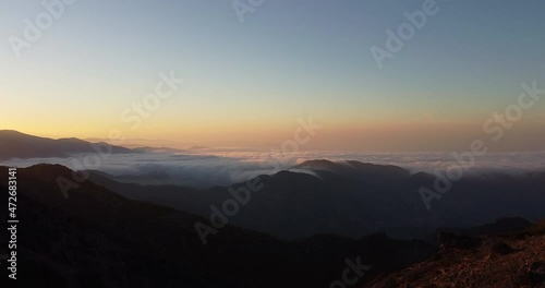 Aerial shot of the peak of the mountain range in Madari Cyprus during sunset. Over the clouds, looking the horizon photo